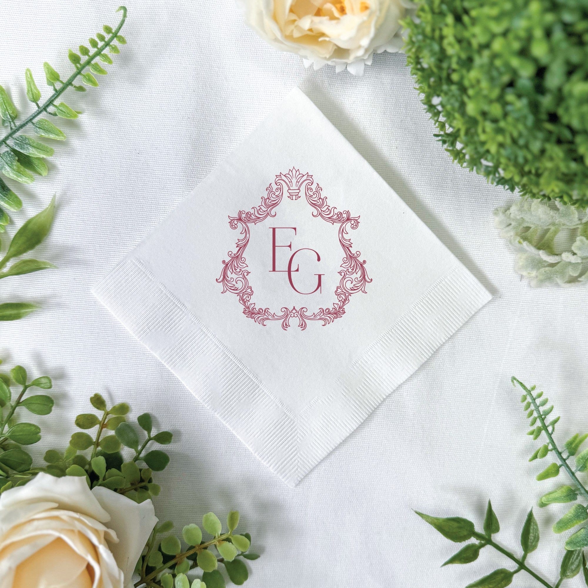 A white paper wedding napkin featuring a red ornate frame design, intended for personalized event decor.