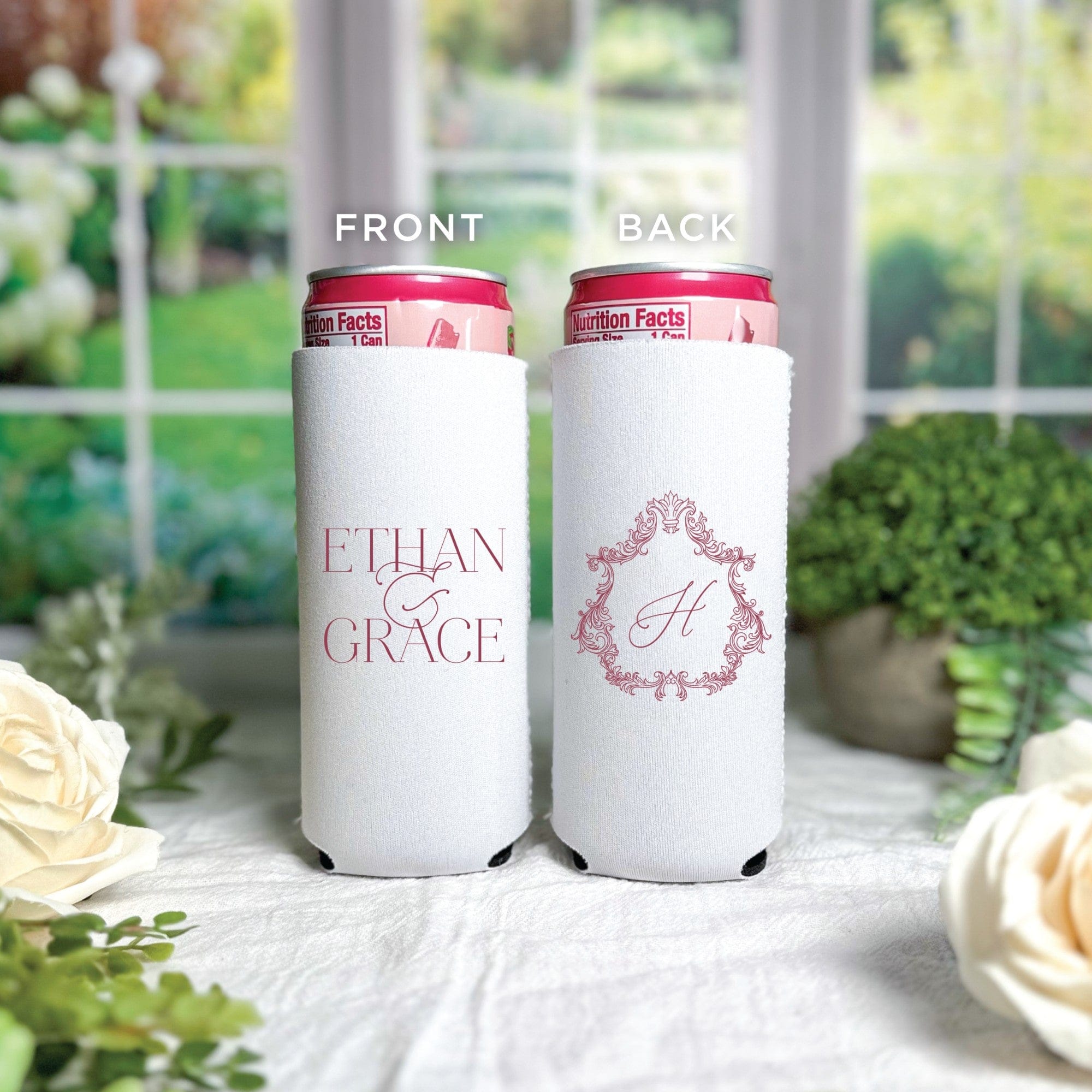 Two white slim can koozies made from soft insulating fabric, one featuring a pink personalized text design and the other a pink monogrammed initial in an ornate frame, suitable for wedding events.