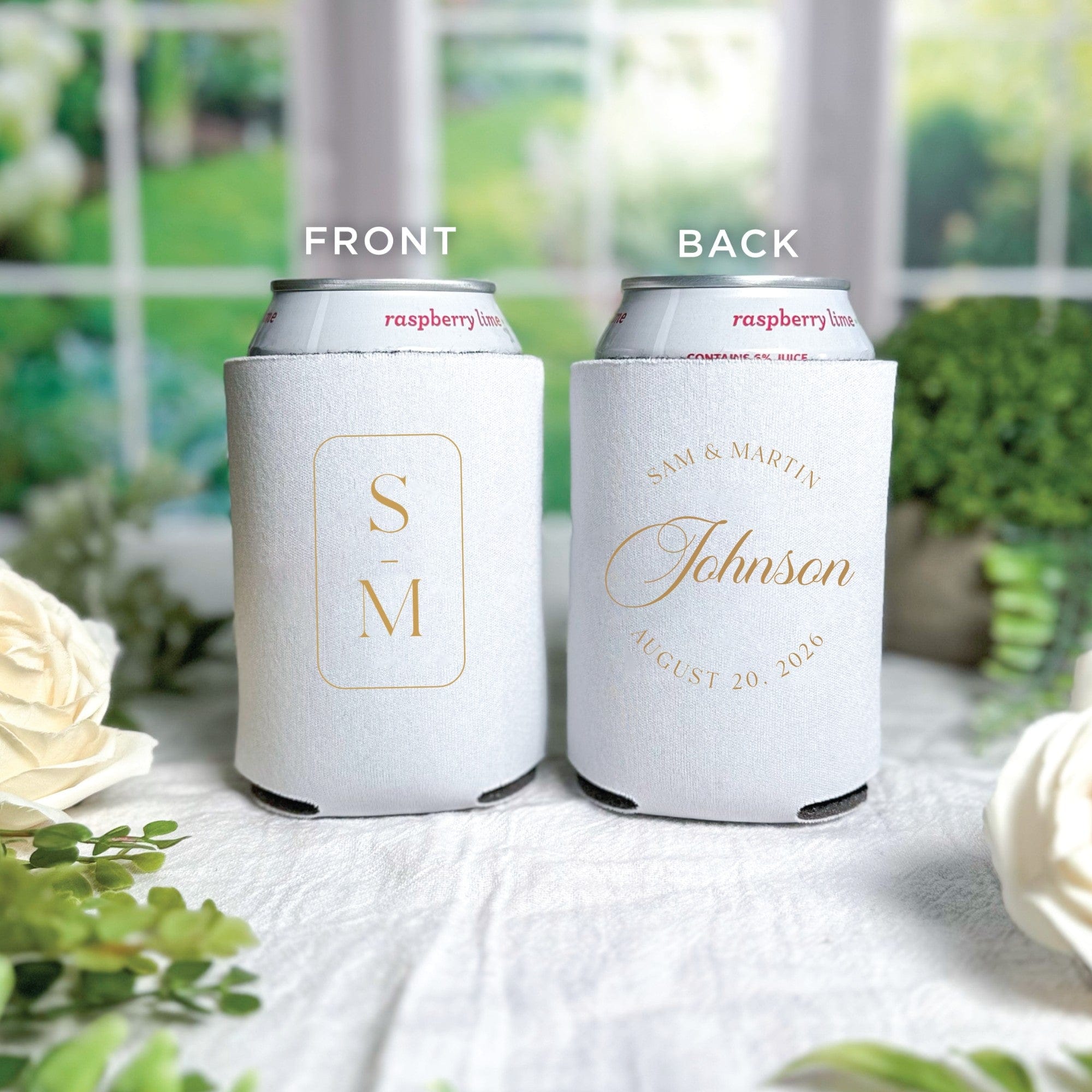 A pair of white neoprene can coolers are shown, featuring a gold framed initial monogram on one side and a personalized gold surname design on the other, intended as a stylish wedding favor.