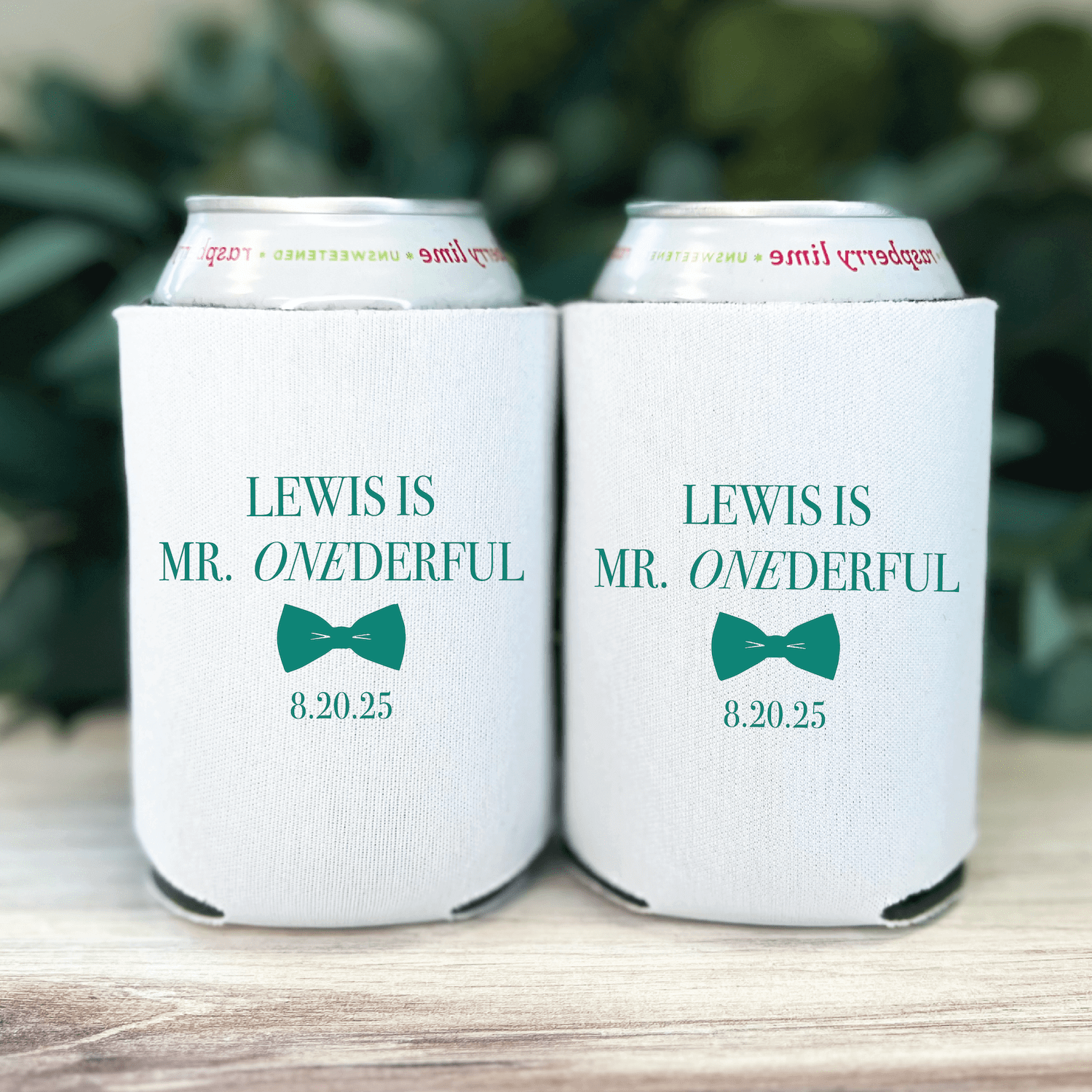 White can coolers with "LEWIS IS MR. ONEDERFUL" text, teal bow tie design, and date 8.20.25 printed on front