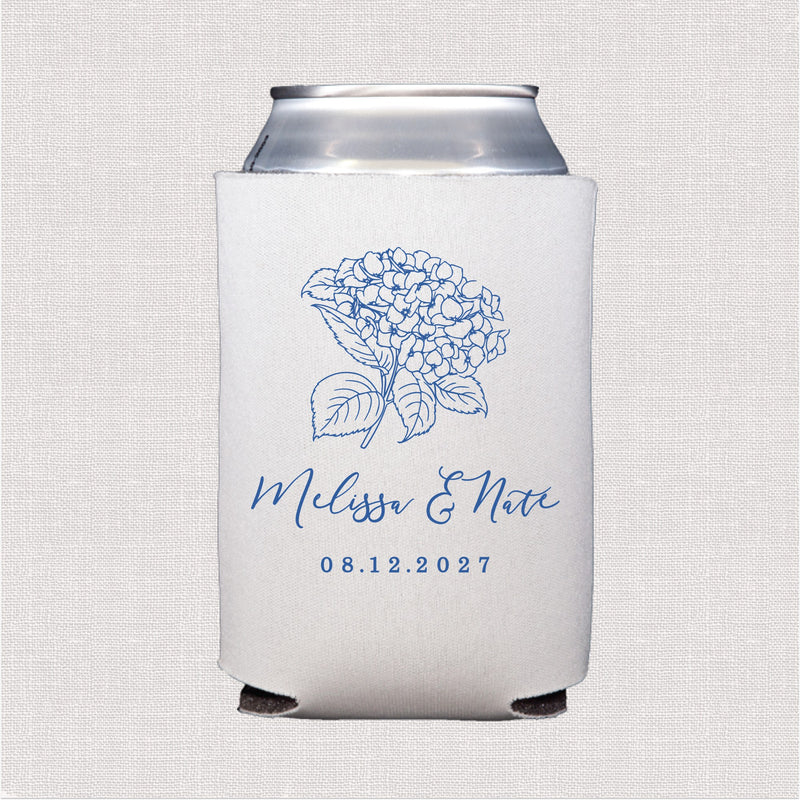A white neoprene can cooler featuring a blue outline hydrangea floral design, perfect for keeping beverages cool at a wedding event.