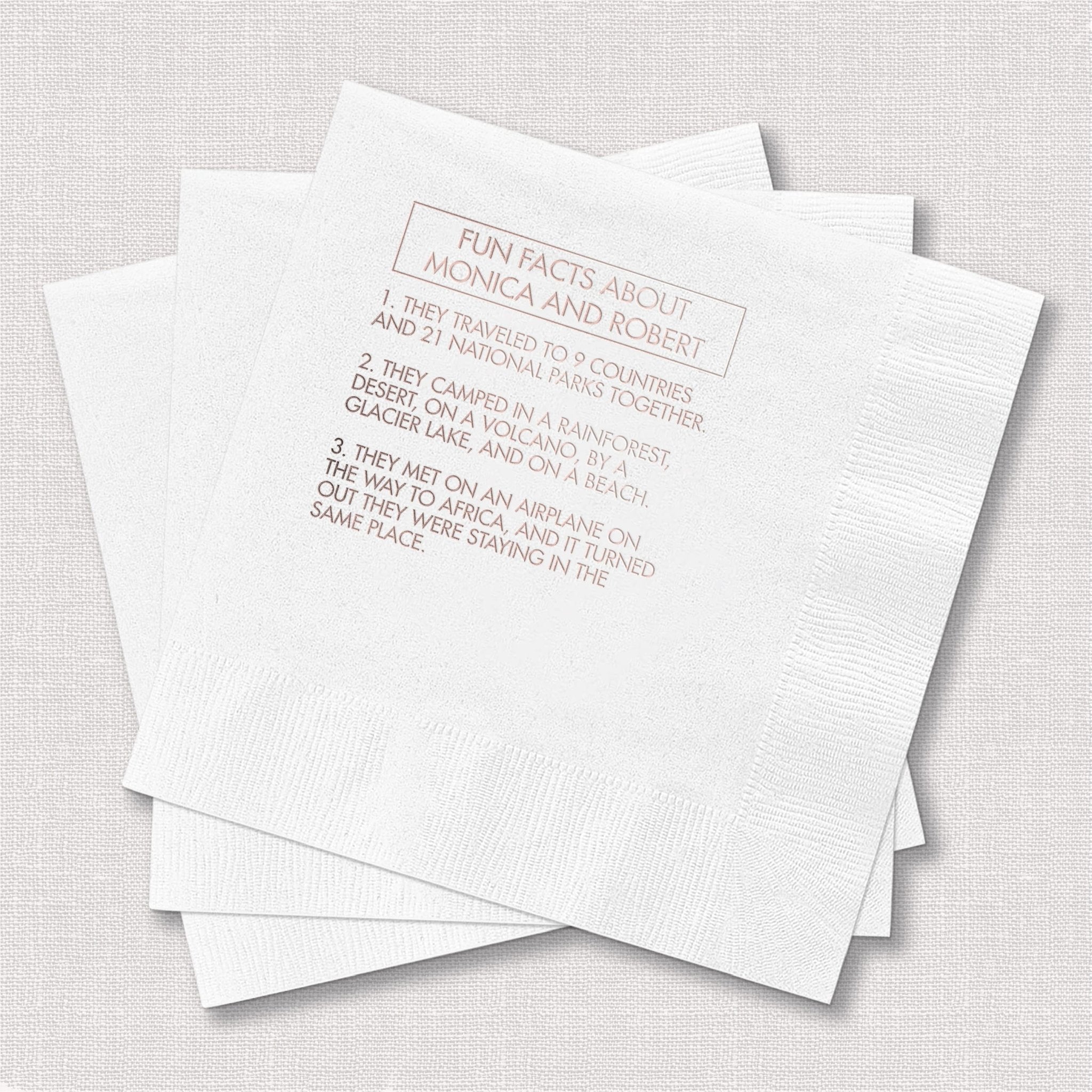 White cocktail napkins with rose gold foil-stamped fun facts about the bride and groom