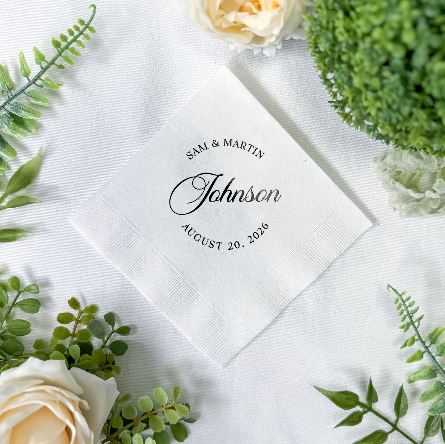 Personalized cocktail napkins with modern monogram design showing couple's names and wedding date