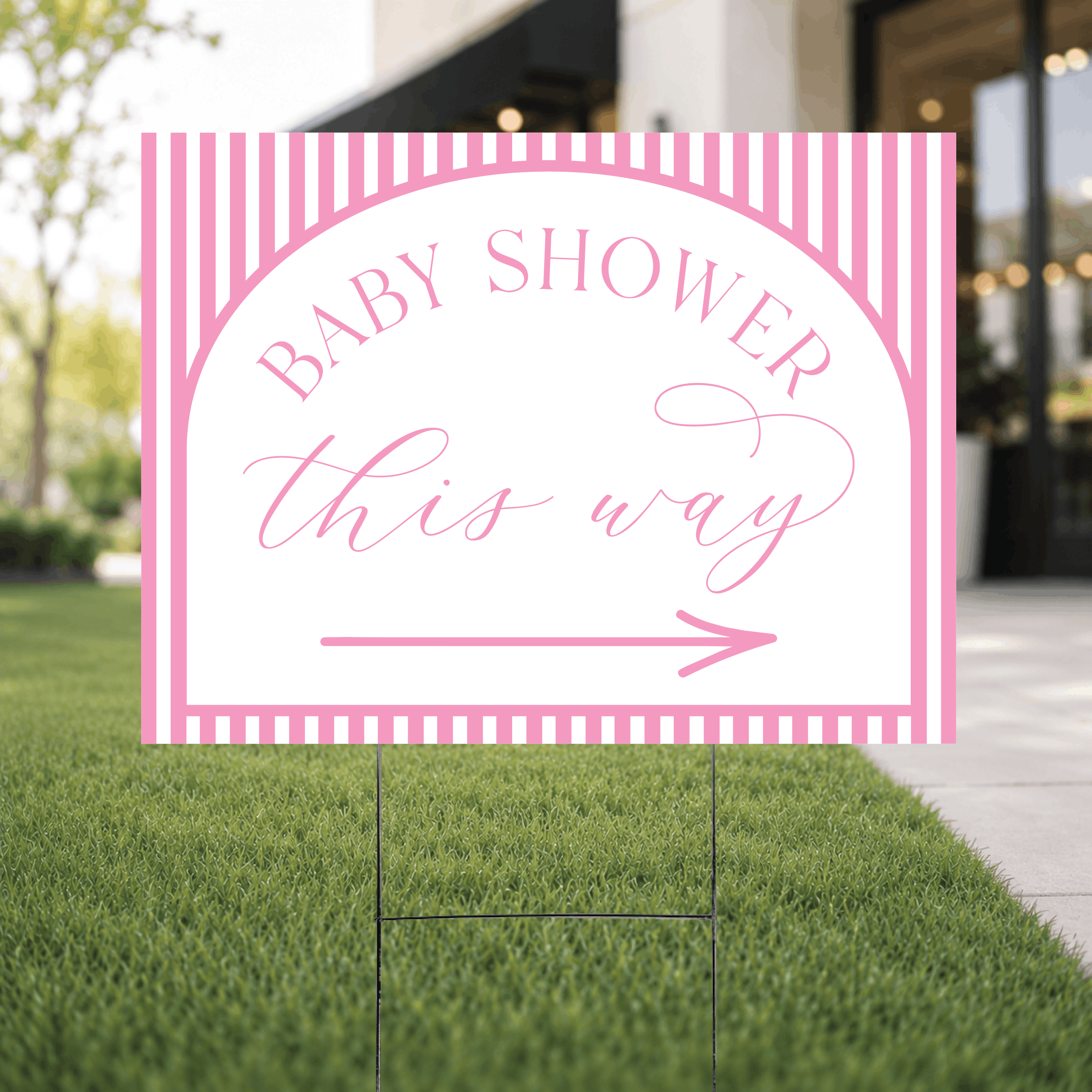 Close-up of a colorful striped baby shower directional yard sign, showcasing the bright striped pattern and crisp UV ink arrow design.