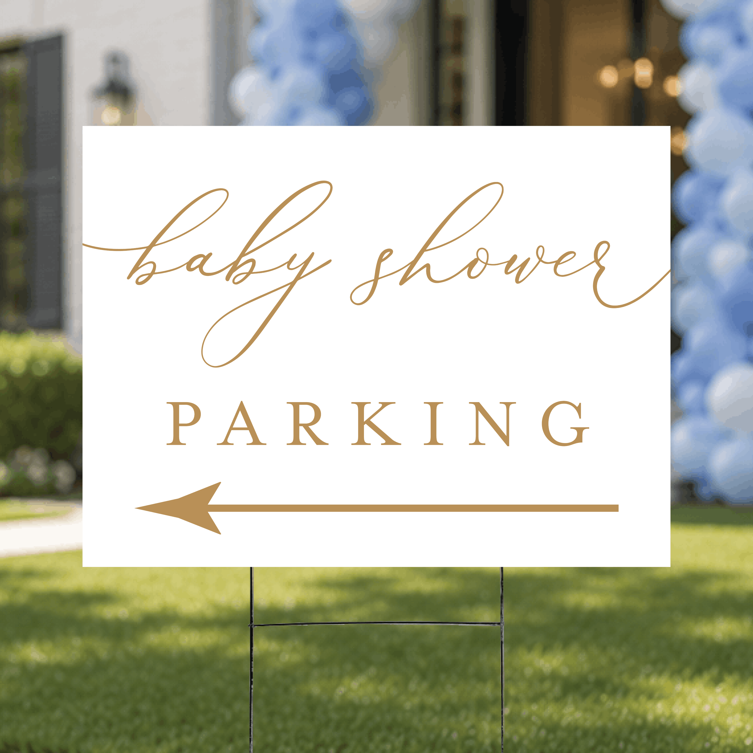 Styled flat lay of a modern script baby shower parking yard sign, highlighting the minimalist white design with script and serif typography and arrow.