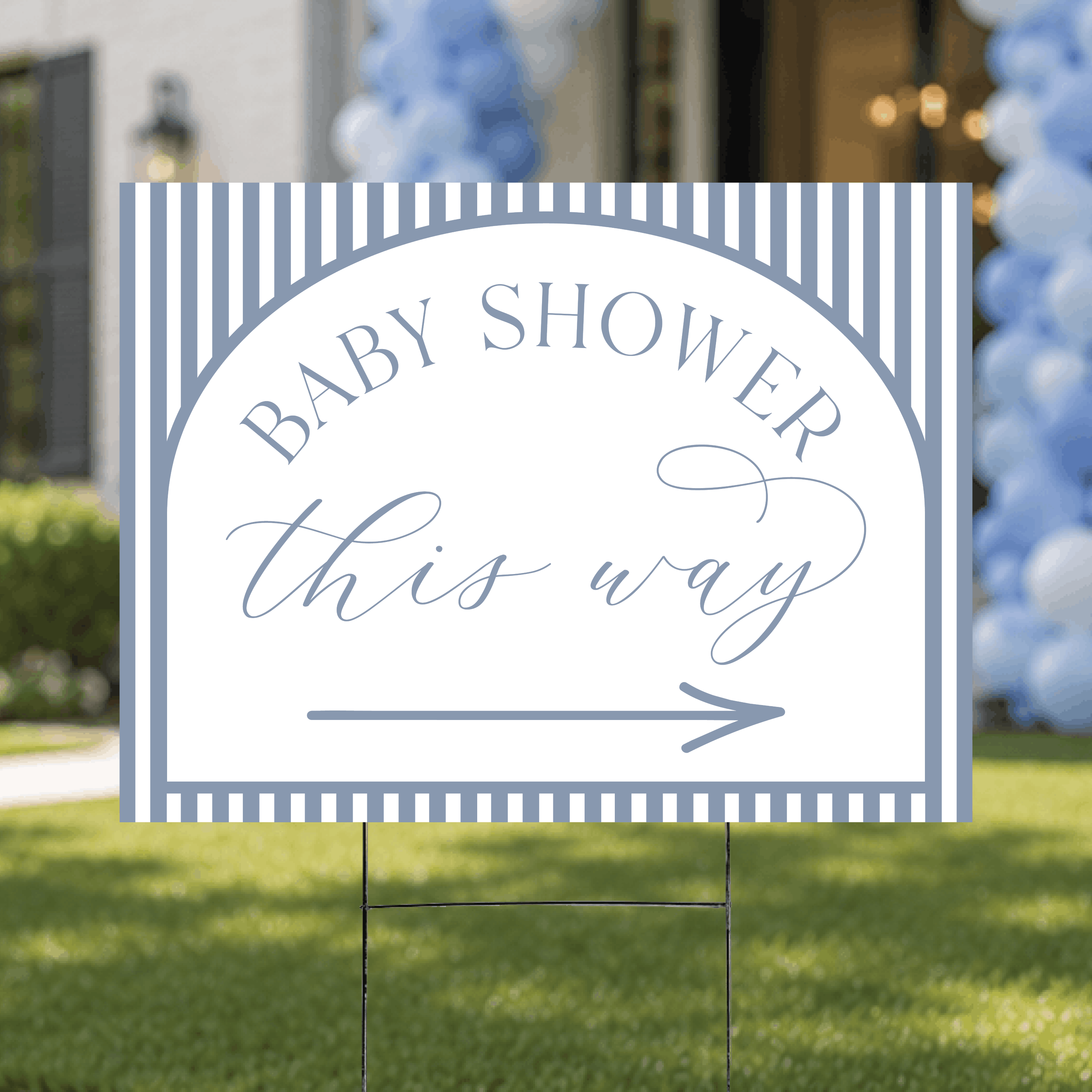 Styled flat lay of a colorful striped baby shower directional yard sign, highlighting the cheerful stripe pattern and arrow design.
