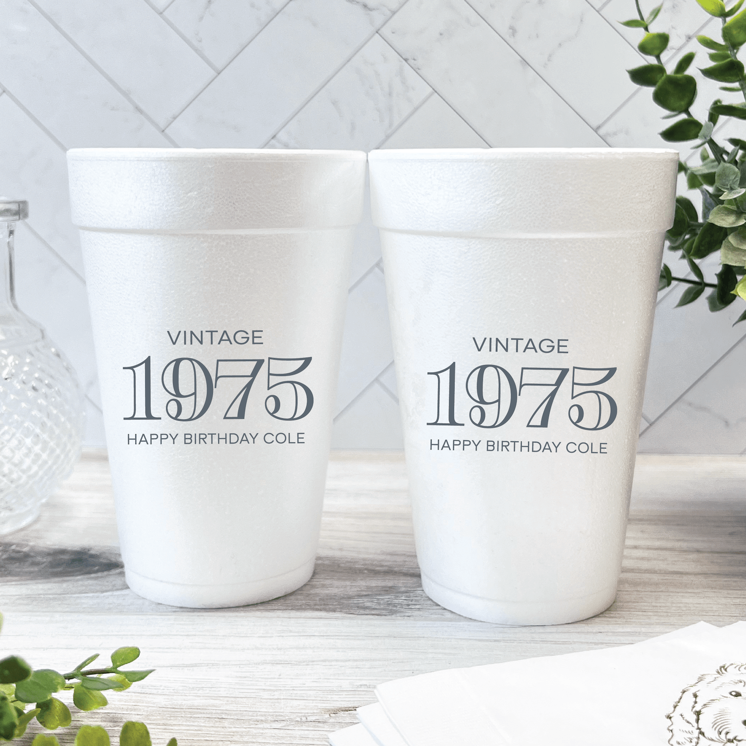 Two white foam cups printed with "Vintage 1975 Happy Birthday Cole" in gray text