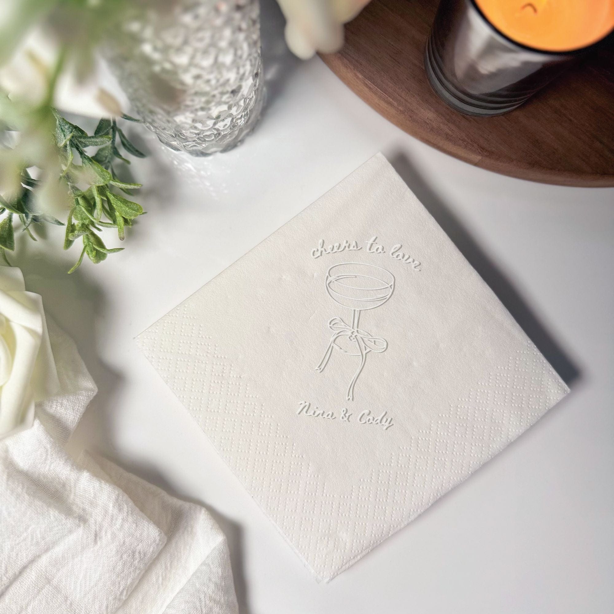 Personalized Embossed Cocktail Napkin Cheers to Love Coupe Bow Ivory Flat Lay – Rubi and Lib