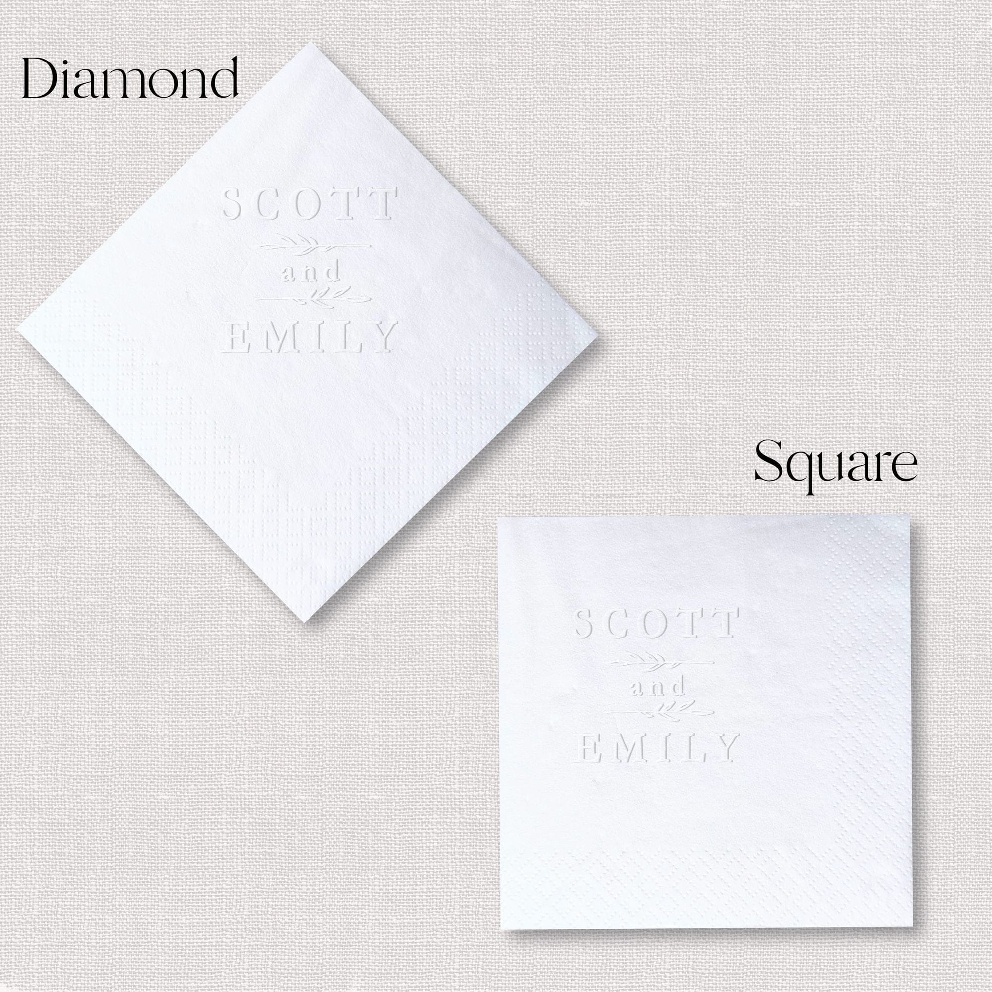 White embossed cocktail napkins in diamond and square shapes with personalized names "Scott" and "Emily" printed in elegant lettering.