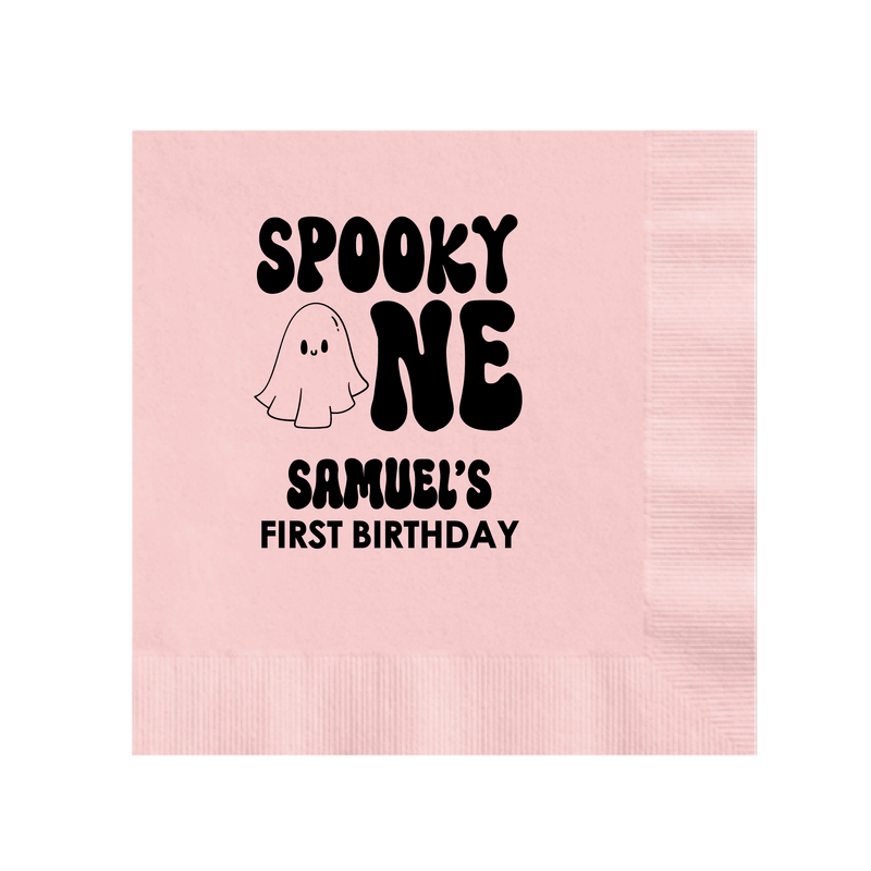 Pink napkin with "Spooky One" text, ghost illustration, and "Samuel's First Birthday" personalization in black print.