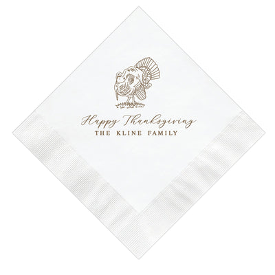 A white paper napkin, folded diagonally, featuring a brown line-art illustration of a turkey and elegant script text, ideal for Thanksgiving celebrations.