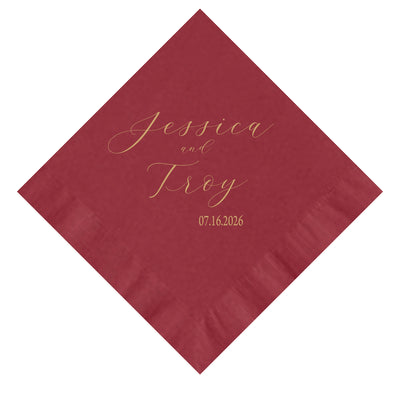 A folded square red paper napkin with elegant gold script personalization, perfect for a wedding or special event.