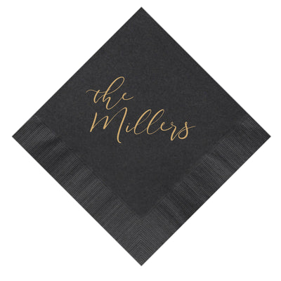 A black disposable napkin, folded diagonally, displays a gold script design along with textured borders, ideal for a wedding or special event.