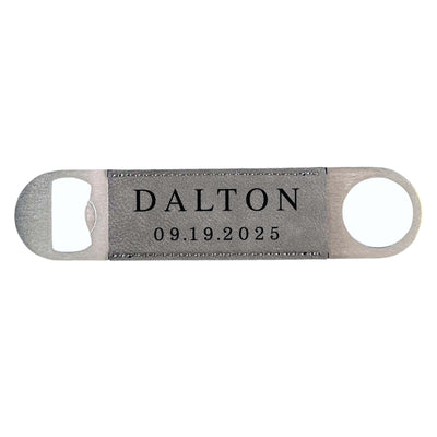A sleek brushed metal bottle opener with a grey faux leather insert featuring visible stitching, suitable for opening beverage bottles.