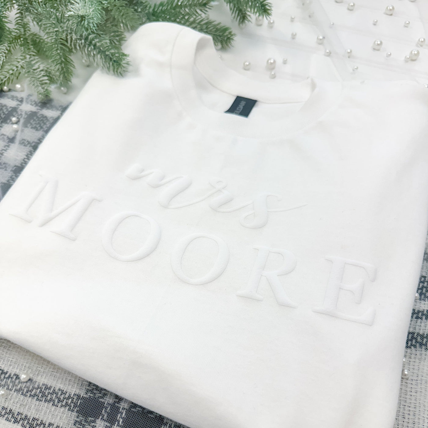 A soft white crewneck sweatshirt, designed for a bridal context, featuring elegant raised 3D lettering on the front.