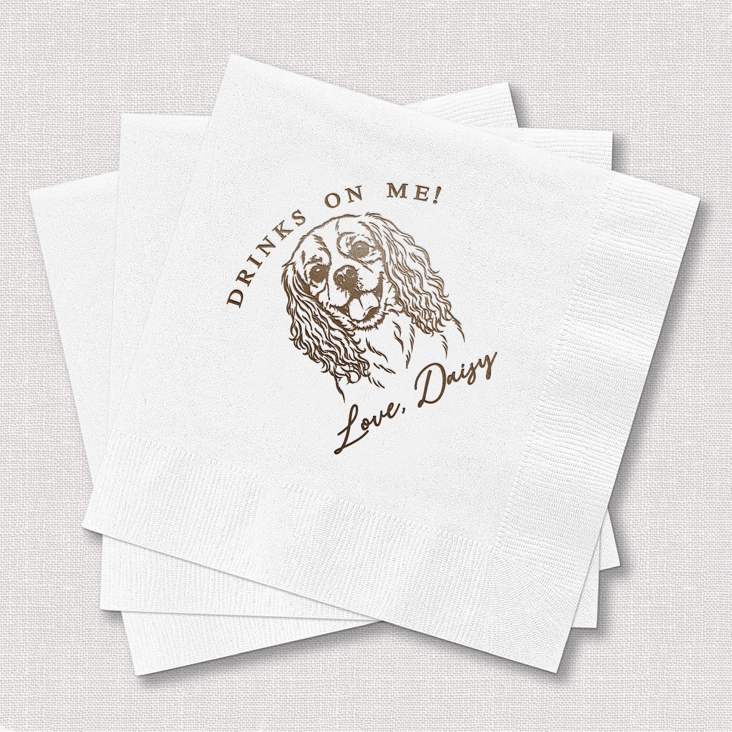 A stack of white paper cocktail napkins, each customized with a brown outline illustration of a dog, perfect for a wedding, party, or special event.