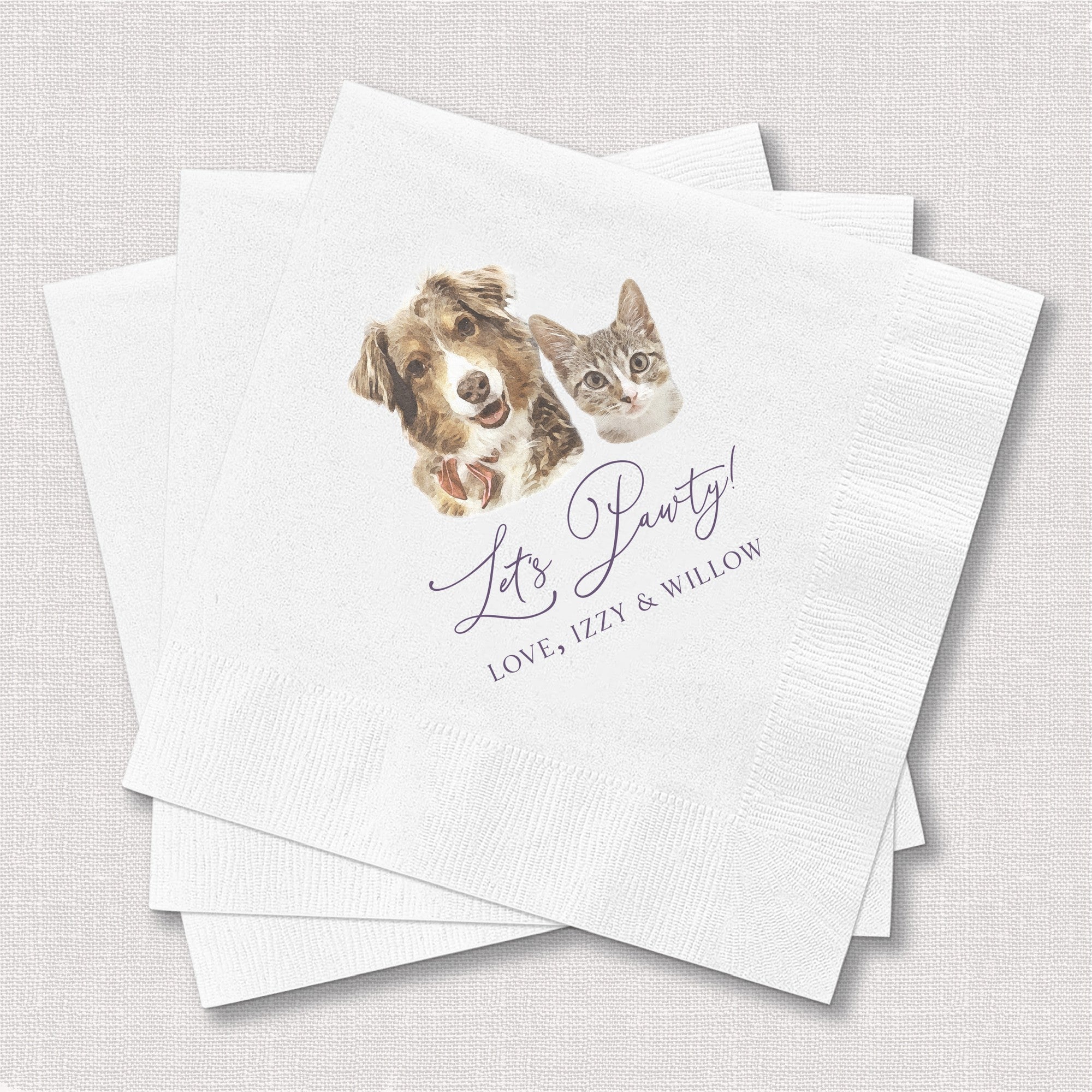 A stack of white textured paper cocktail napkins features a custom watercolor-style illustration of a dog and a cat, along with playful purple script text, perfect for a pet-themed party or celebration.