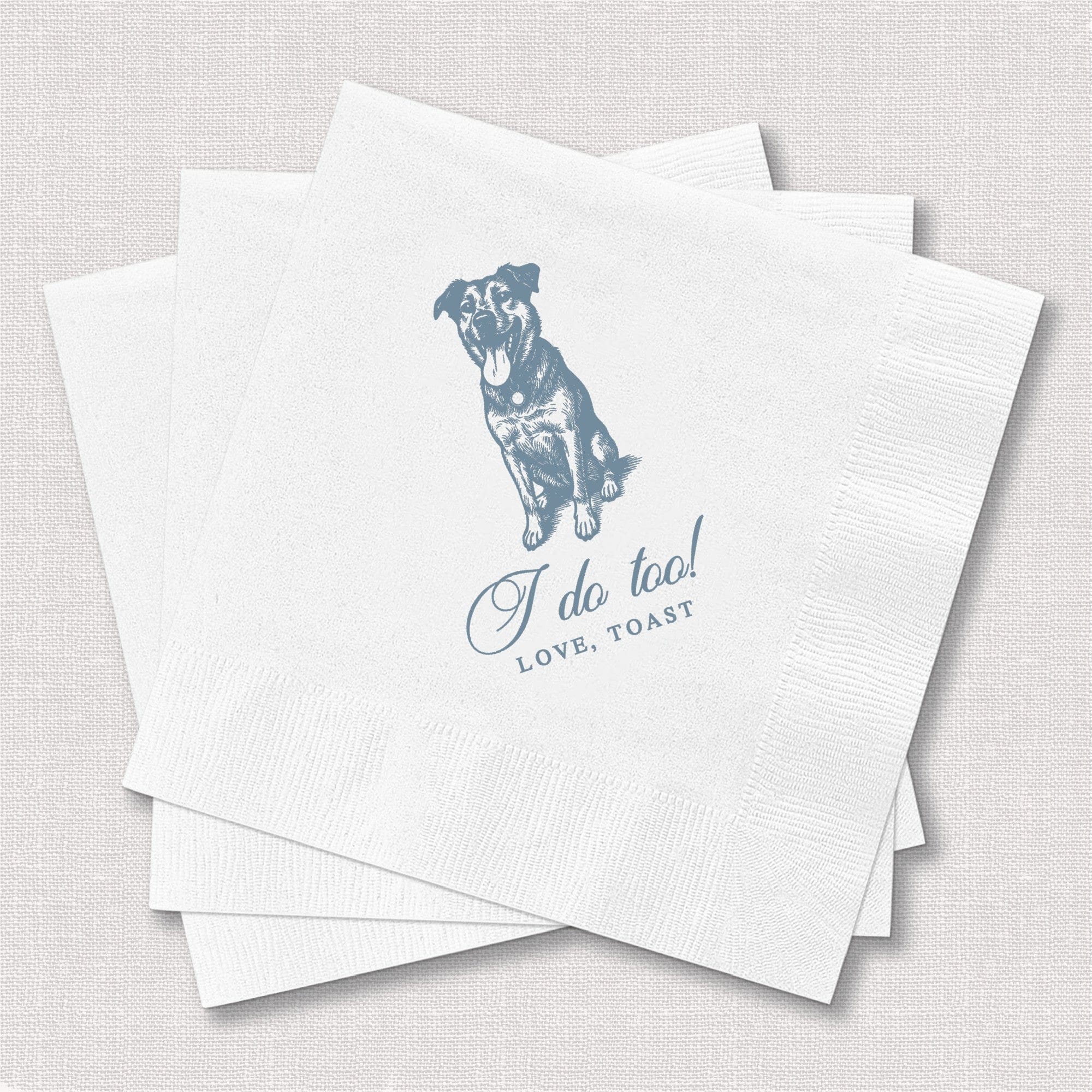 A stack of white paper cocktail napkins, personalized with a blue illustration of a happy dog, ideal for a wedding or special event.