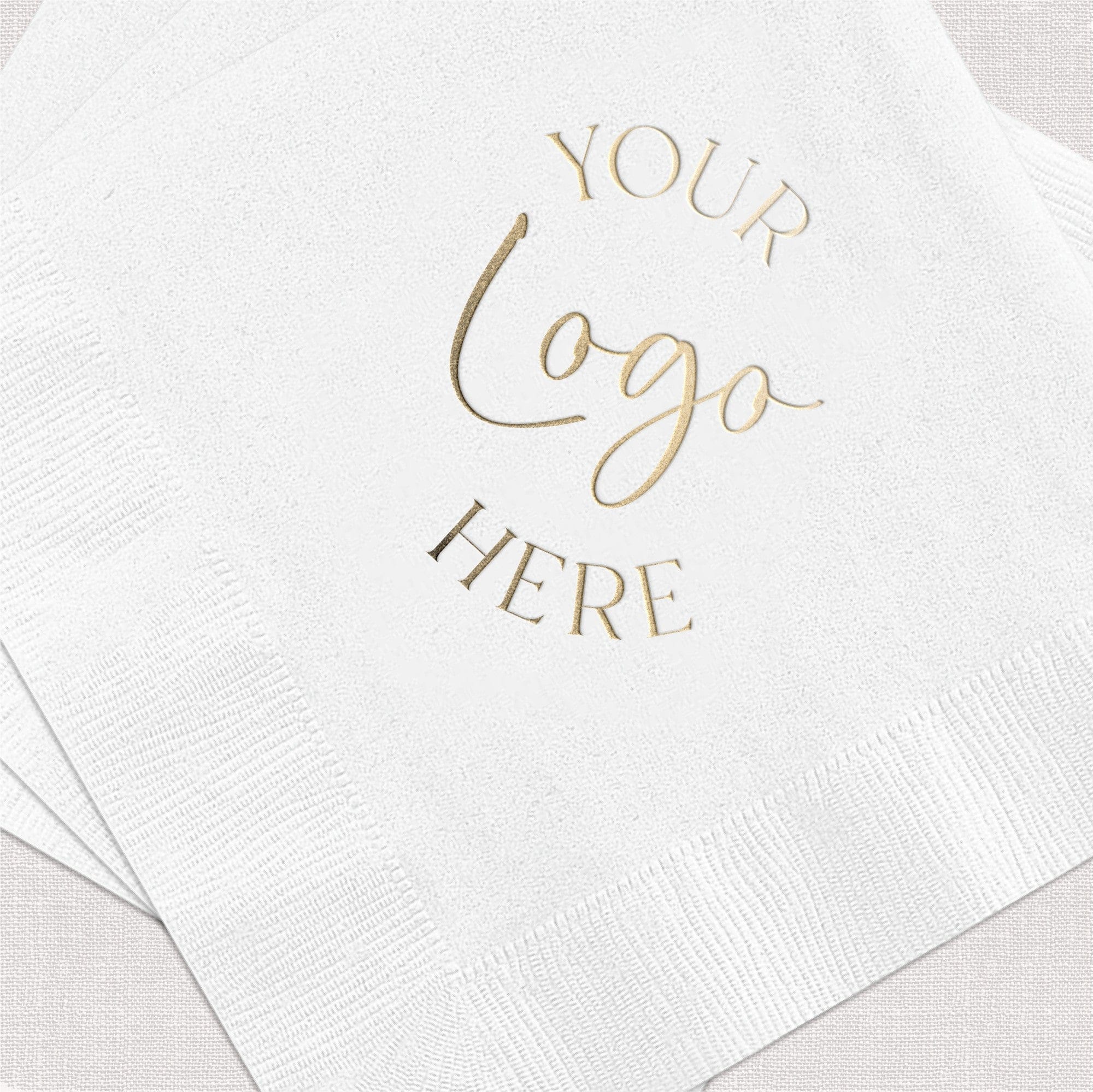 A stack of white textured paper napkins featuring a custom gold foil design, perfect for personalized wedding or event decor.