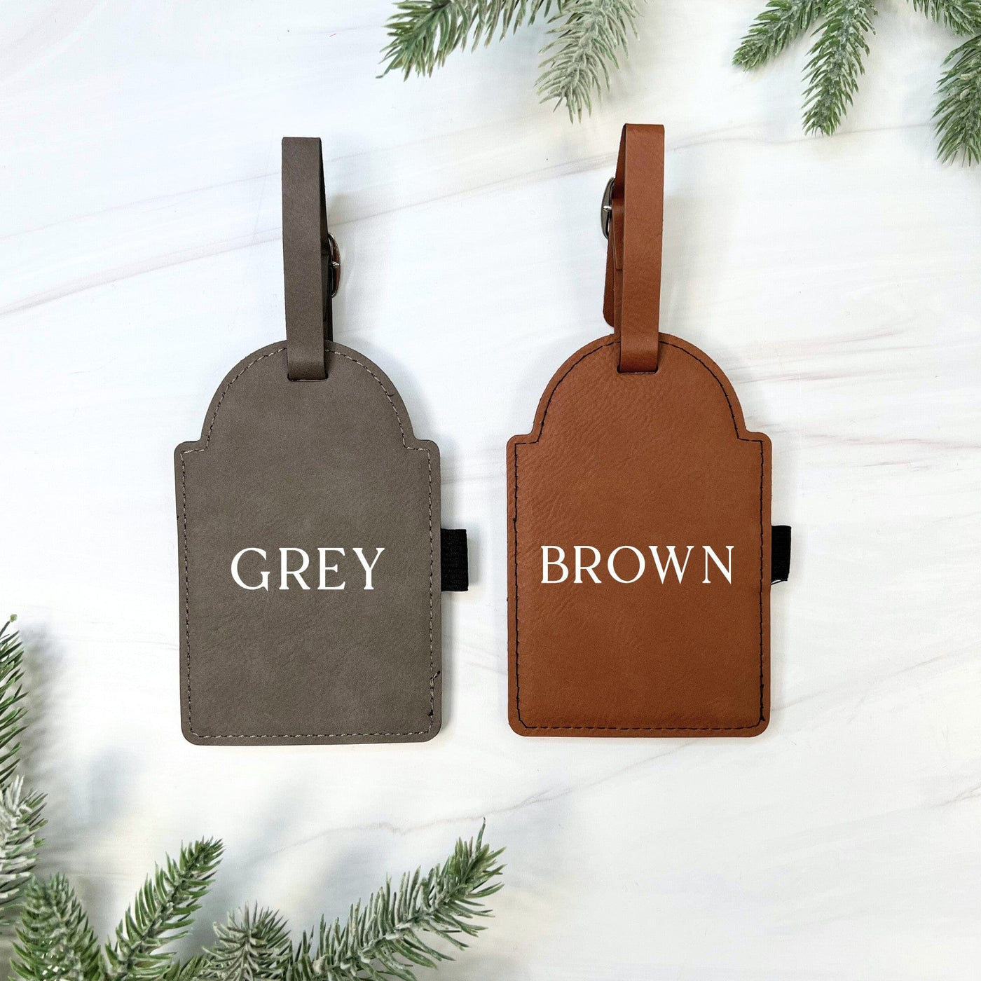 A pair of arched faux leather golf bag tags, one in grey and one in brown, showcasing color options for personalized event decor.