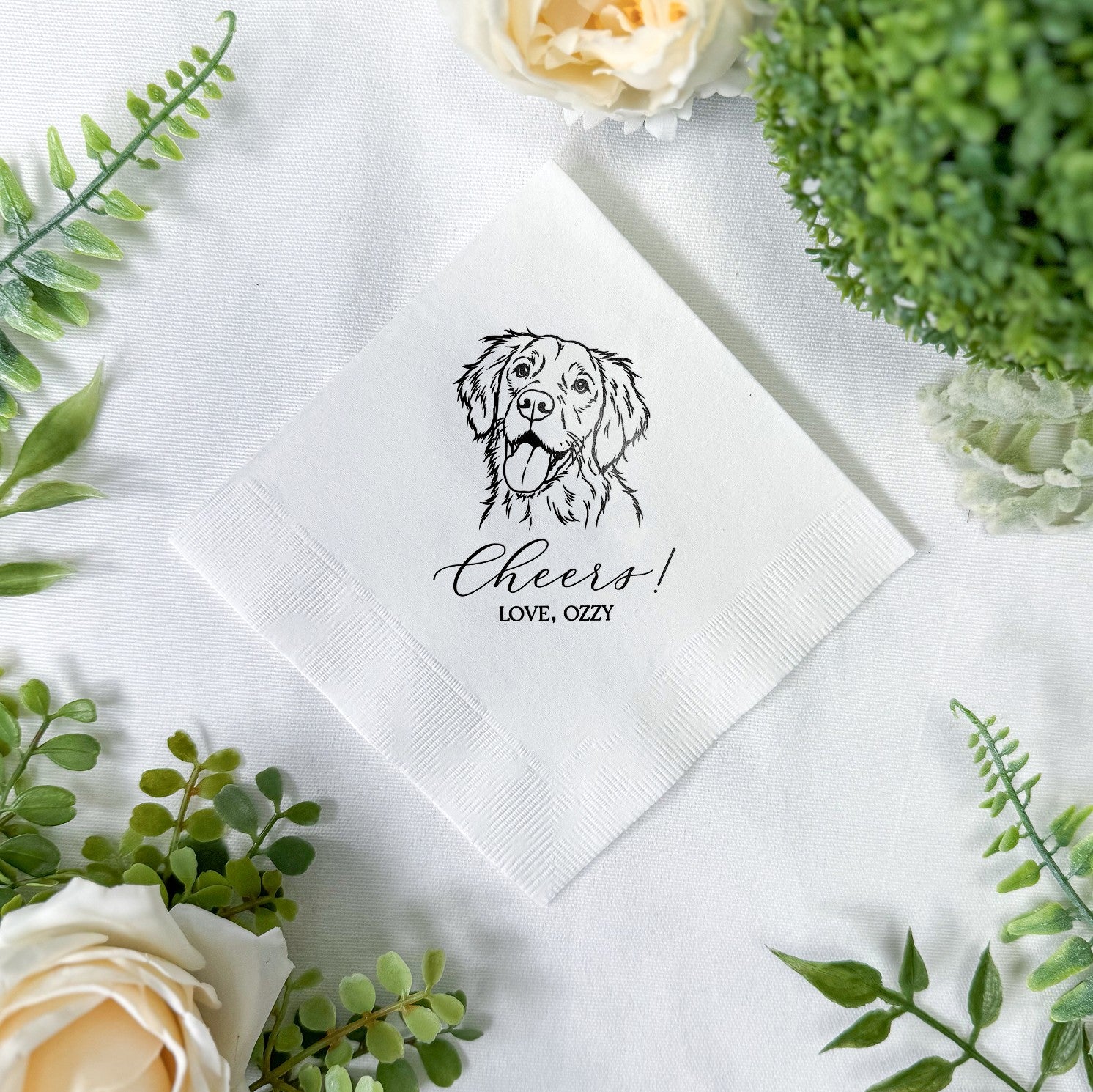 A white folded paper napkin featuring a custom black line-art illustration of a happy dog, perfect for wedding receptions, bridal showers, or other special events.
