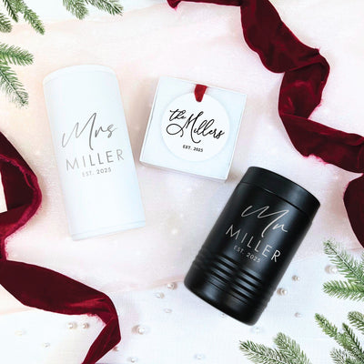 A personalized wedding gift set featuring a white and a black insulated beverage cooler, accompanied by a round white ornament, designed to celebrate a newly married couple.