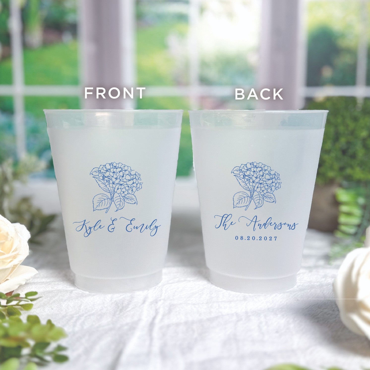 Two frosted shatterproof plastic cups are displayed, featuring a blue hydrangea floral design, suitable for personalized wedding or event decor.