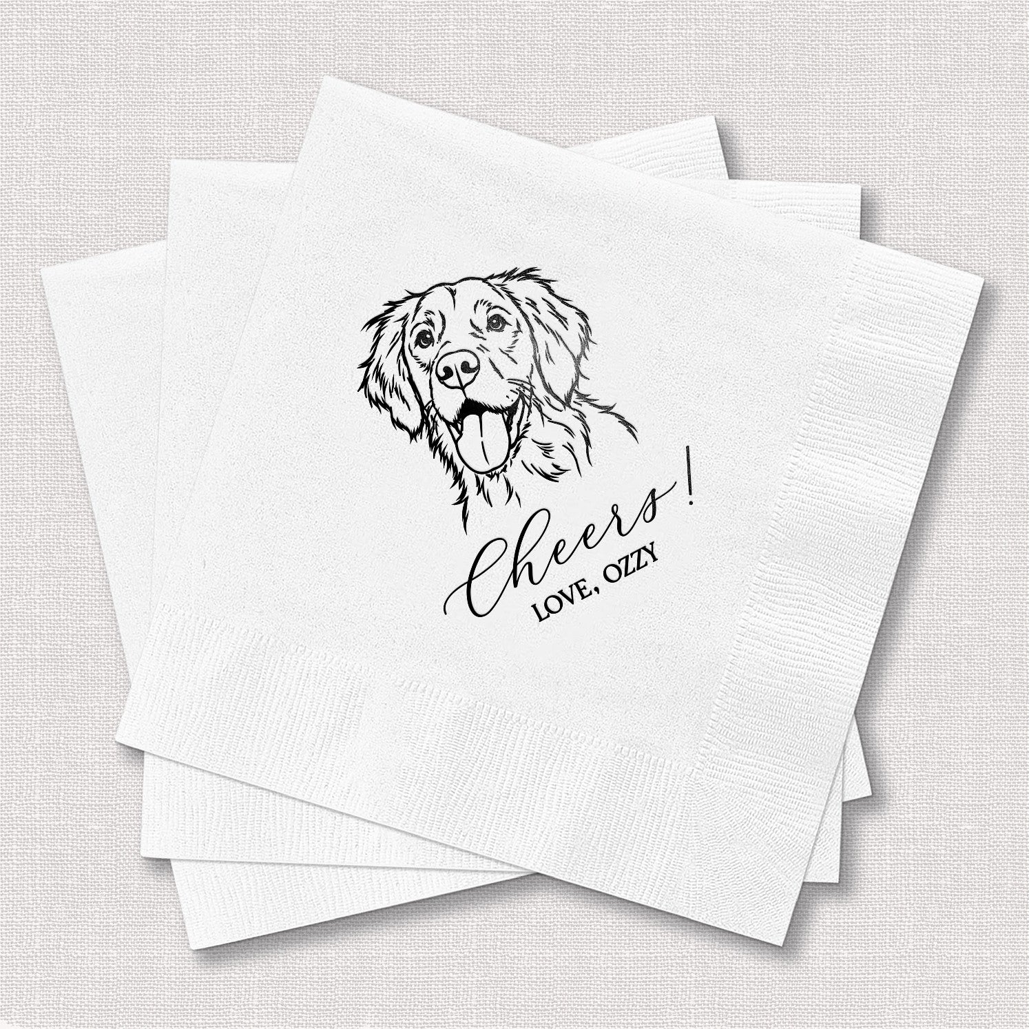 Three white paper event napkins are stacked, featuring a black line-art illustration of a happy dog and celebratory script text.