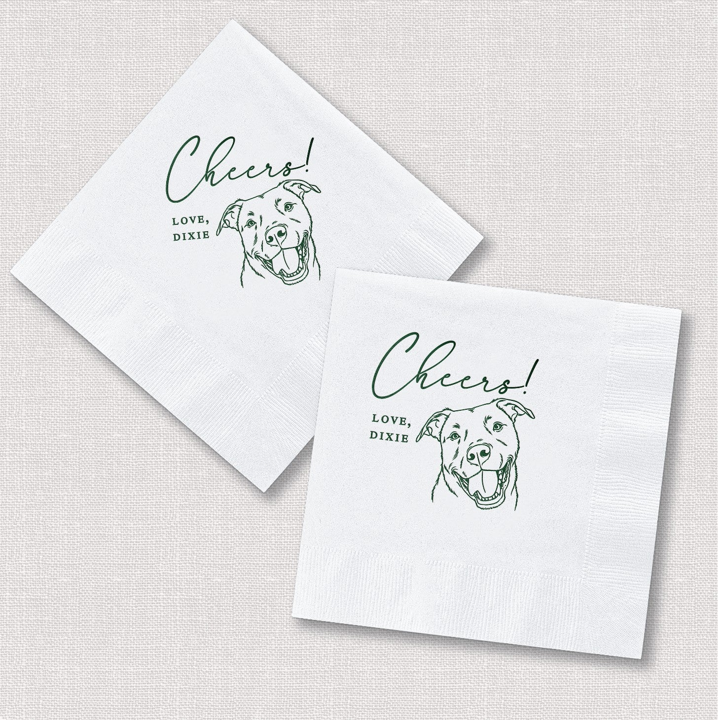 Two white square paper napkins featuring a green line art illustration of a smiling dog and personalized script text, ideal for wedding or event celebrations.