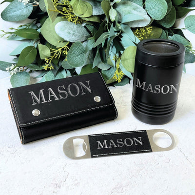 A personalized black faux leather poker chip case, a matching insulated can cooler, and a stainless steel bottle opener with faux leather detail are displayed, designed as a coordinated gift set for events.