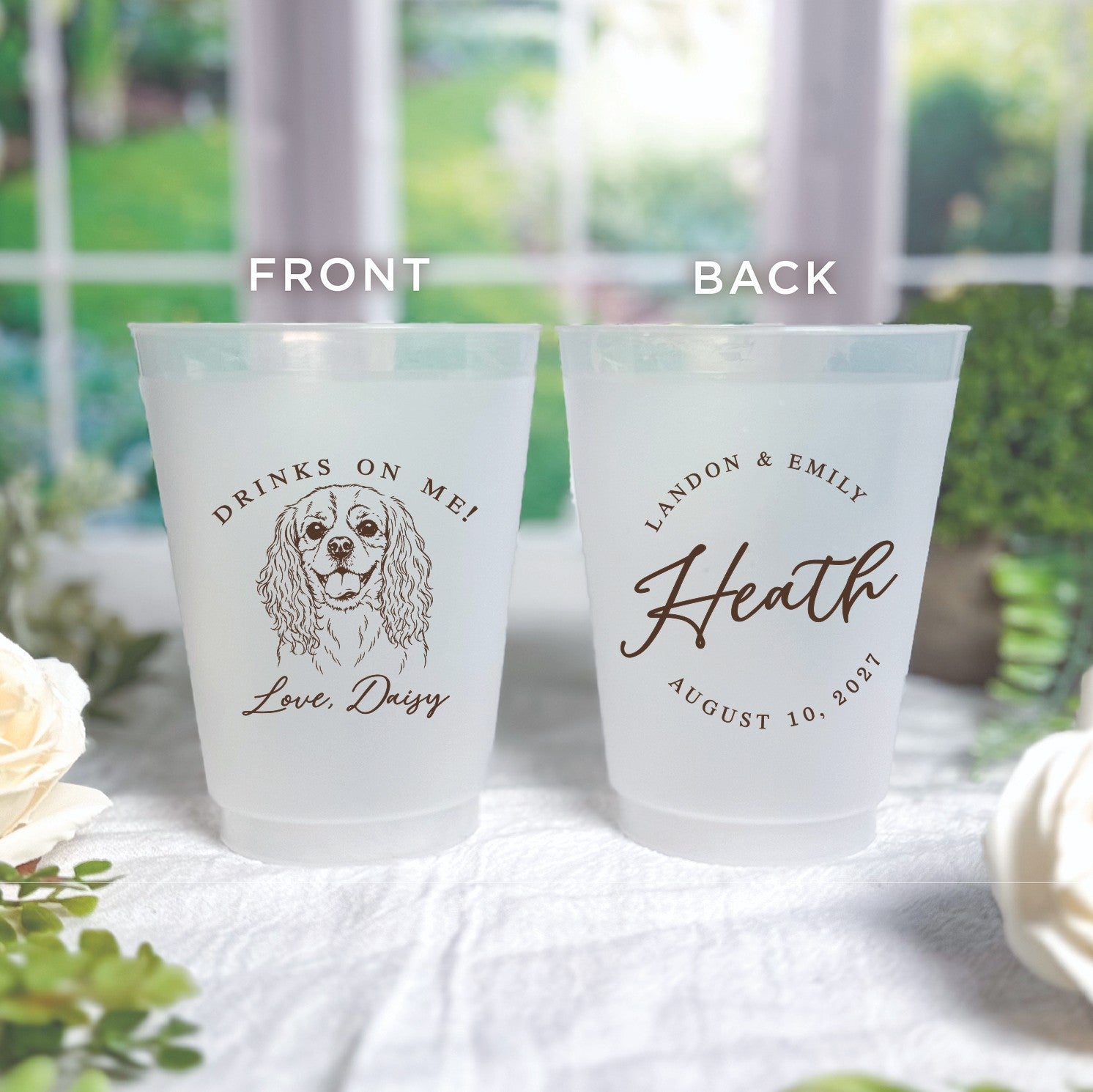 A pair of frosted, shatterproof plastic cups featuring custom brown print with a playful dog illustration on the front and elegant text details on the back, perfect for a personalized wedding or event.