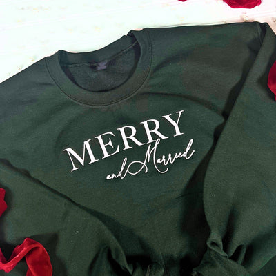A dark green fabric sweatshirt featuring white decorative lettering, suitable for a winter wedding celebration or bridal event.