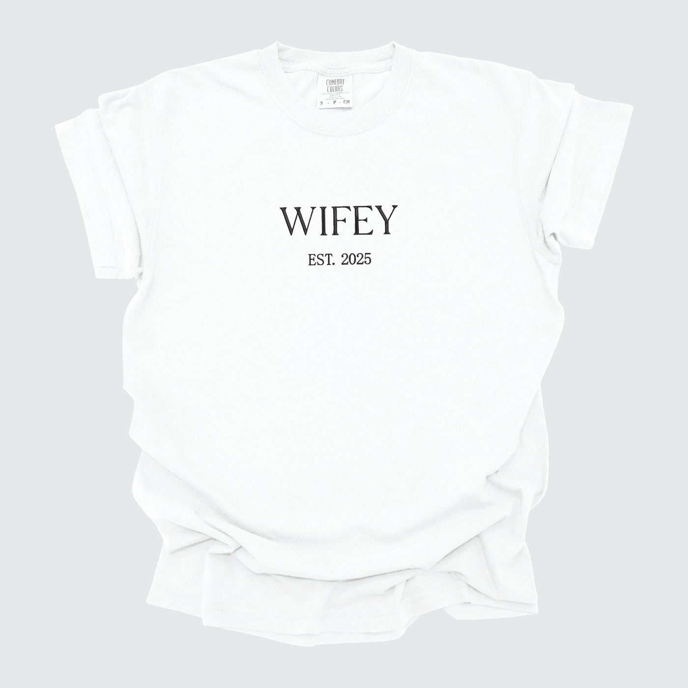 A neatly folded white short-sleeved t-shirt crafted from comfortable fabric, ideal for bridal events.