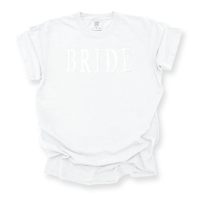 A white short-sleeve t-shirt features subtle white raised lettering, perfect for bridal events.