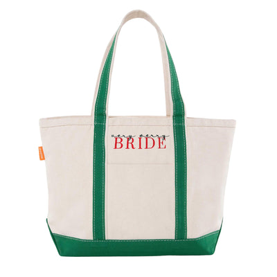 A sturdy natural canvas tote bag featuring festive forest green accents on the handles and a reinforced bottom, suitable for a holiday-themed wedding or bridal celebration.