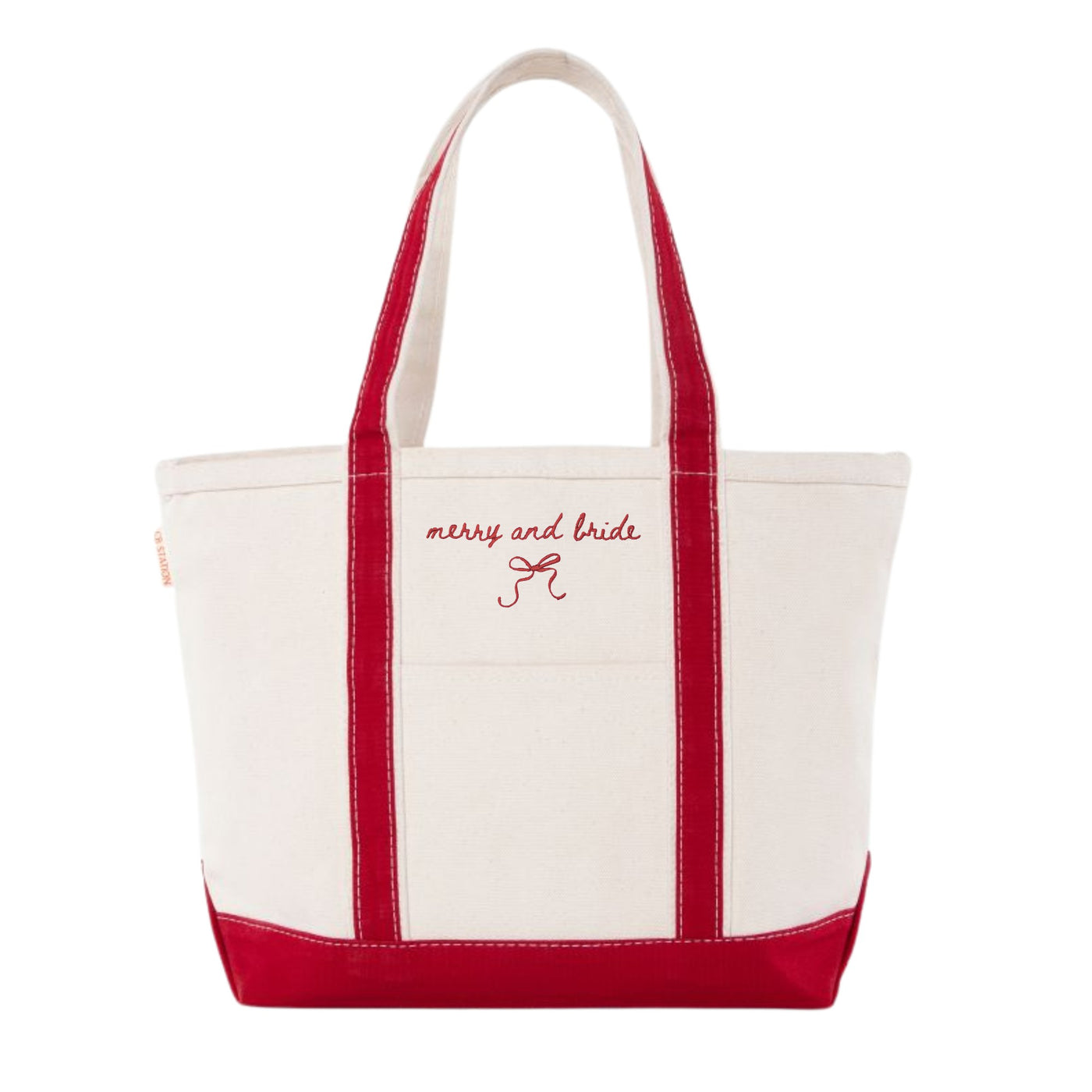 A natural canvas wedding tote bag with bright red handles, trim, and base, featuring festive red embroidered text and a small bow graphic on the front.
