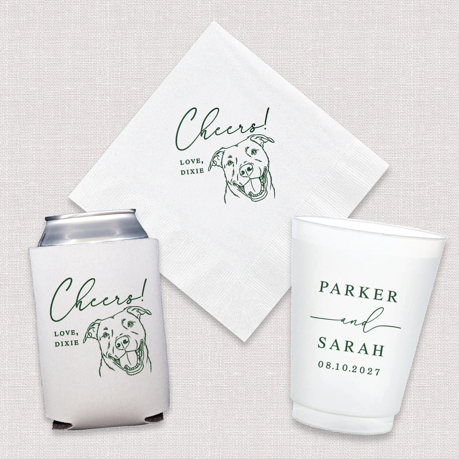 A personalized wedding and event decor bundle includes a white paper napkin, a white neoprene can cooler, and a white frosted plastic cup, all featuring green custom designs such as a cheerful pet illustration and celebration text.