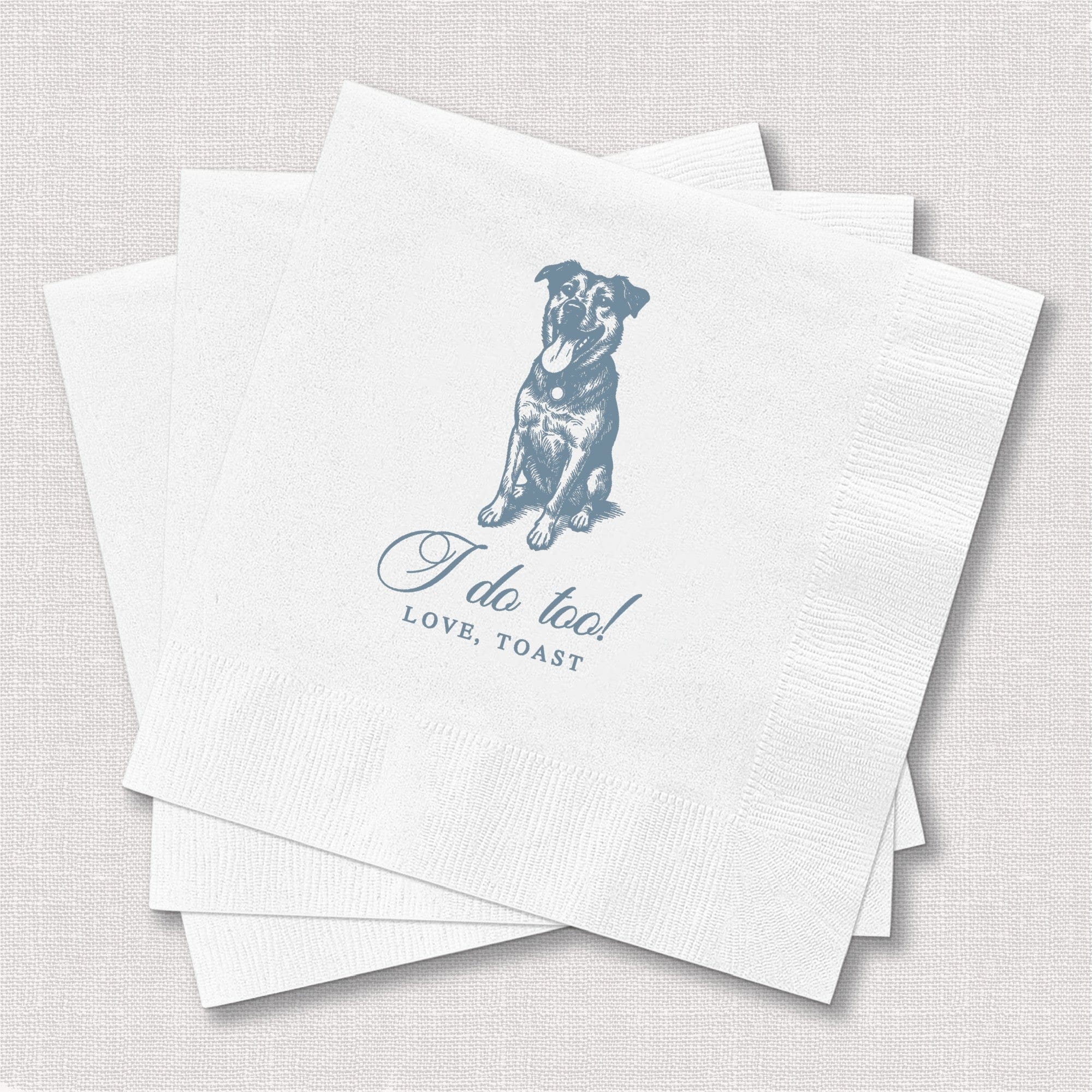 A stack of white textured paper napkins featuring a blue illustration of a dog and celebratory text, designed for a wedding or engagement party.