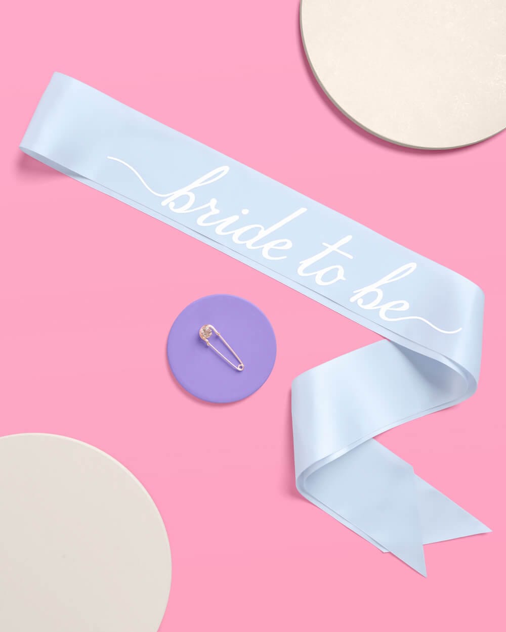 Light blue satin sash with white "bride to be" script text on pink background
