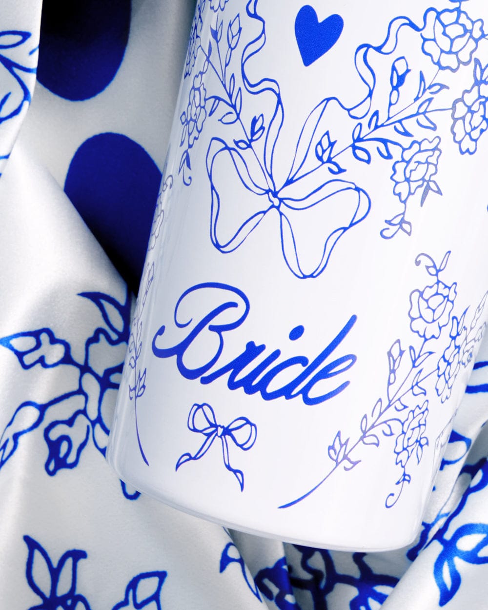 White 24 oz tumbler with blue floral design, heart, and "Bride" text in script lettering