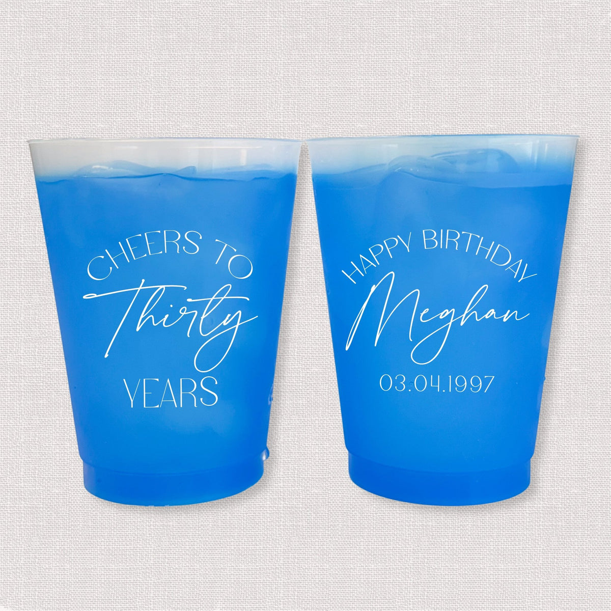 Blue color changing frosted birthday cups with Cheers to Thirty Years arch and Happy Birthday Meghan personalization