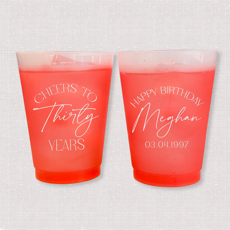 Red color changing frosted birthday cups with Cheers to Thirty Years arch and Happy Birthday Meghan personalization