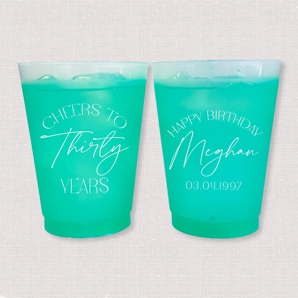 Teal color changing frosted birthday cups with Cheers to Thirty Years arch and Happy Birthday Meghan personalization