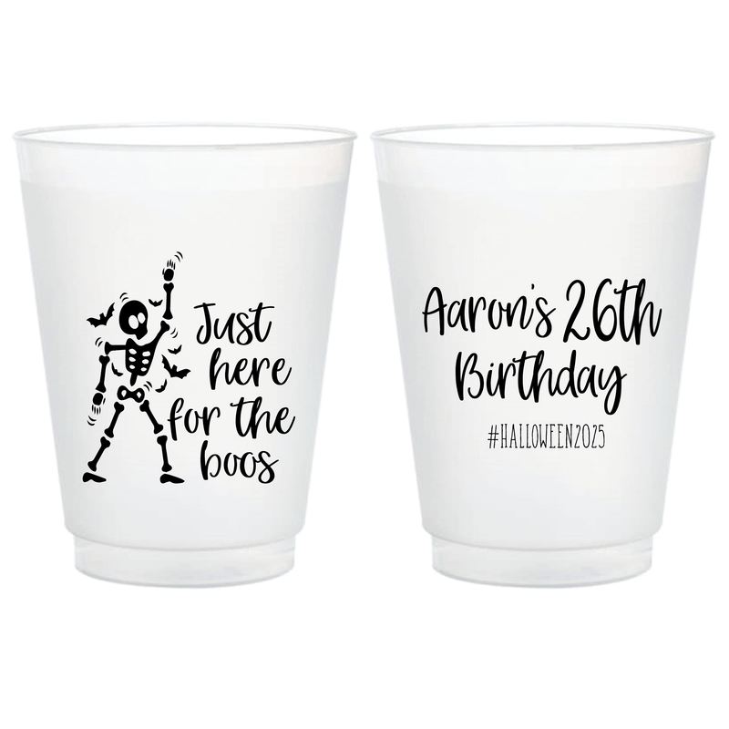 Pair of frosted shatterproof cups with Halloween skeleton design and personalized birthday text, one side reads "Just here for the boos" with skeleton graphic, other side reads "Aaron's 26th Birthday #Halloween2023"