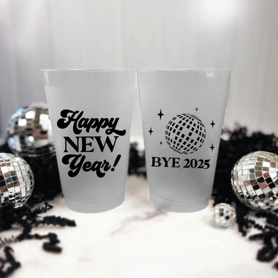 Two frosted translucent plastic party cups, one featuring a 'Happy New Year' message and the other a disco ball graphic with stars, designed for a festive New Year's celebration.