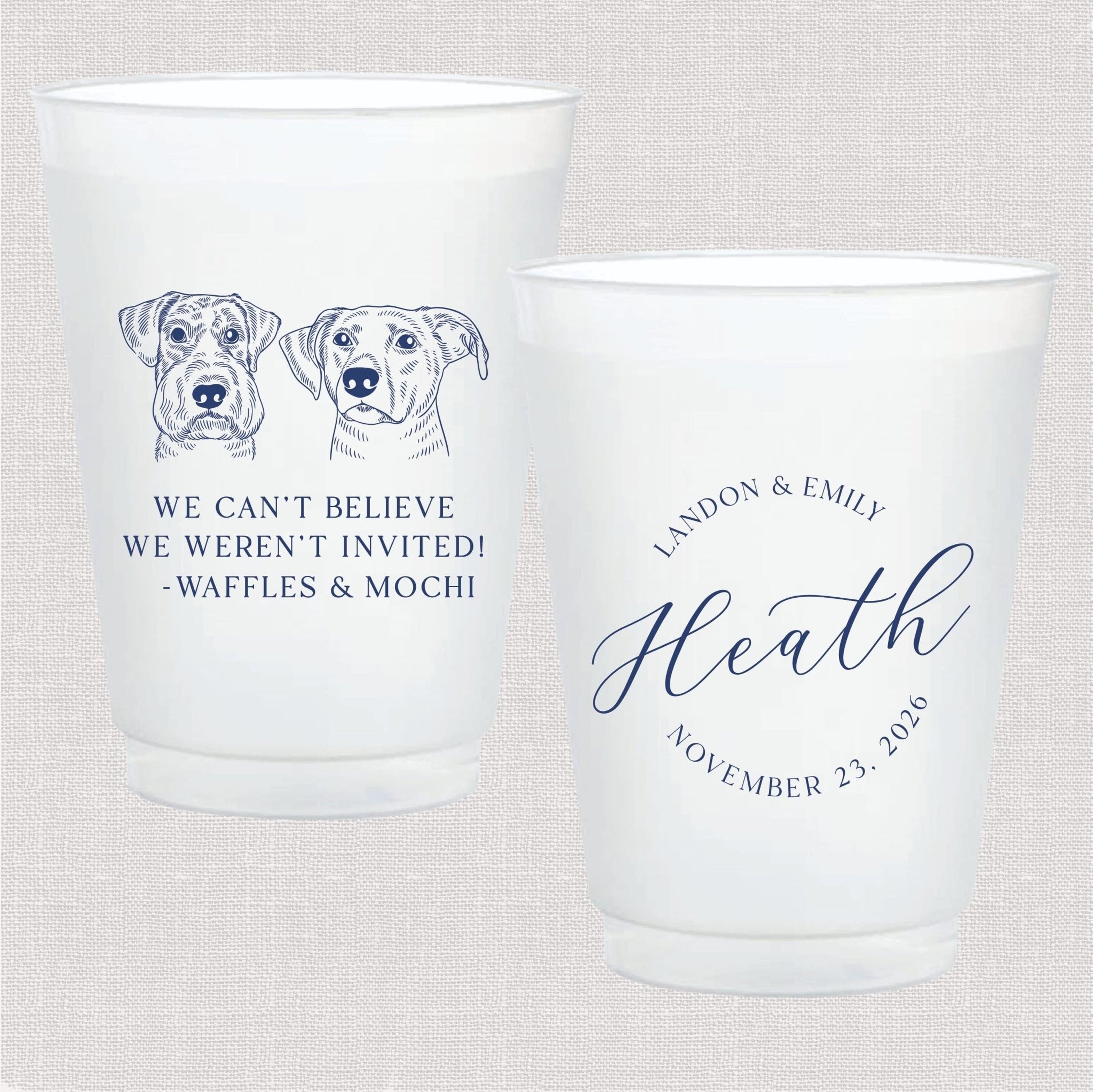 Two frosted cups with navy blue dog illustrations and personalized text, one reading "We can't believe we weren't invited Waffles & Mochi" and the other "Landon & Emily Heath November 25 2023"