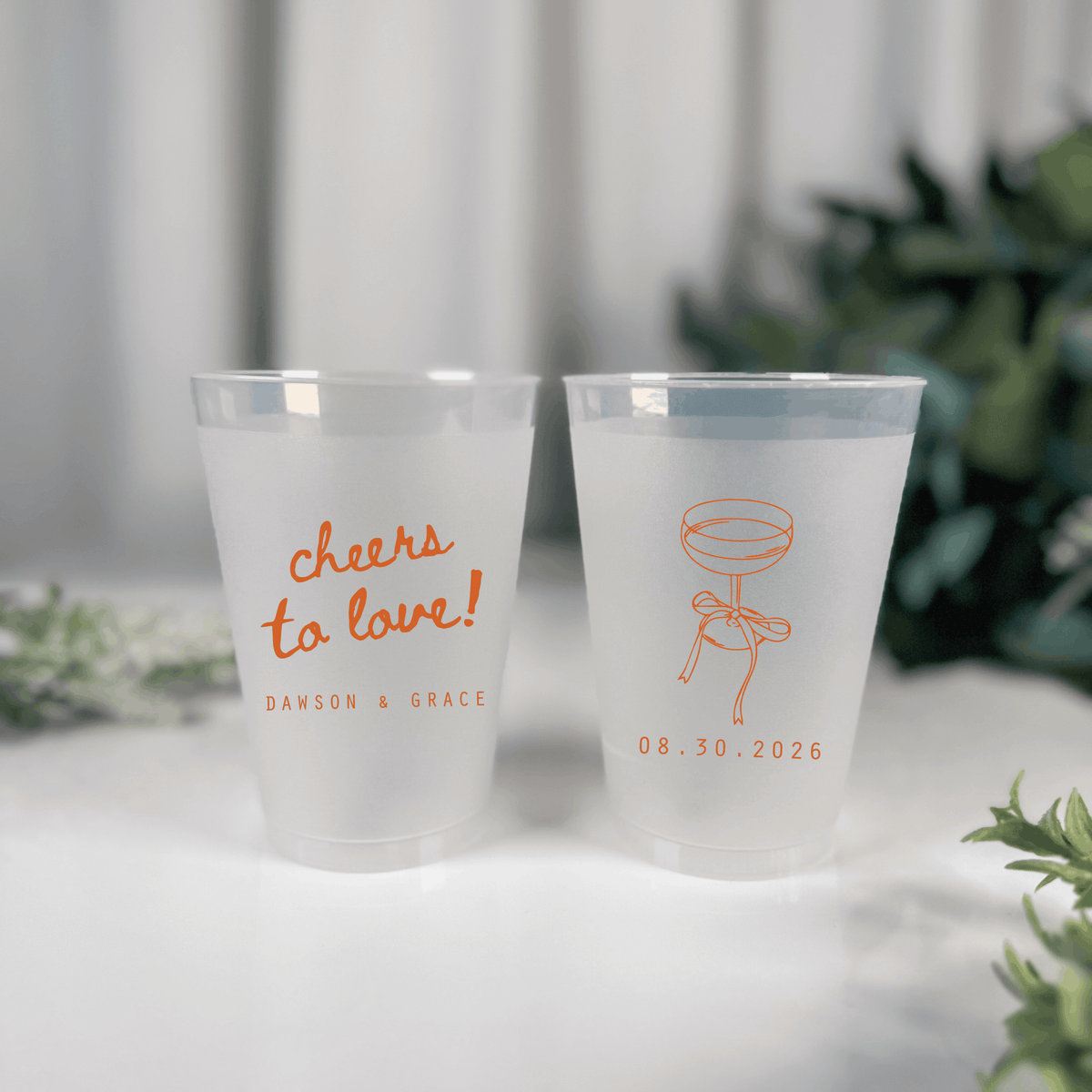 Orange ink frosted shatterproof wedding cups with cheers to love script, champagne coupe and wedding date