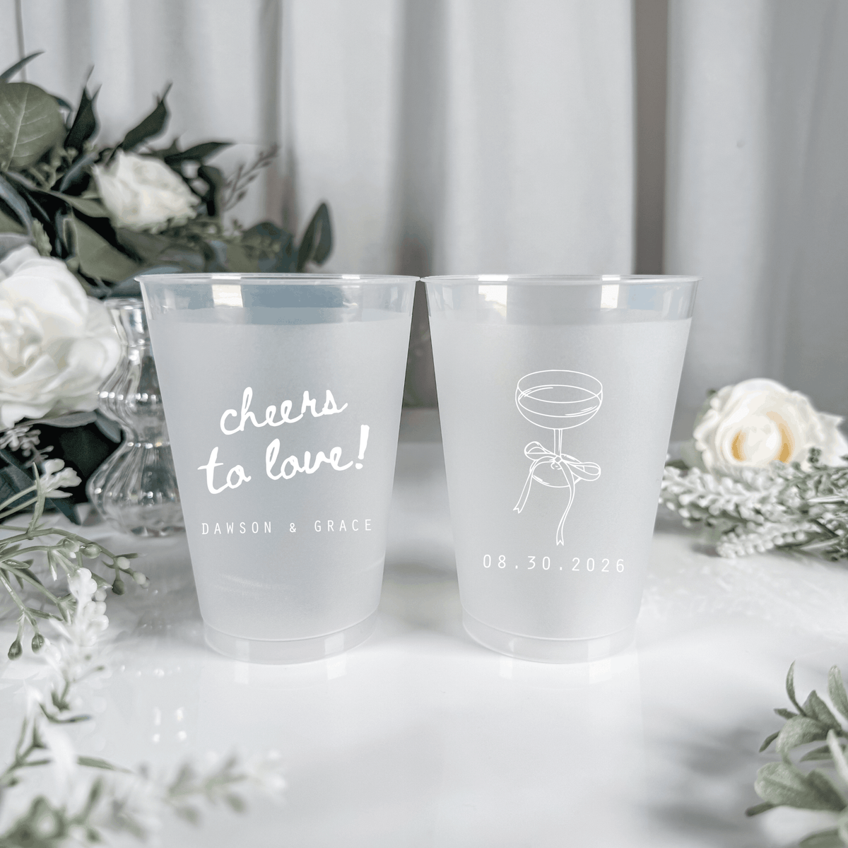 White ink frosted shatterproof wedding cups with cheers to love script, champagne coupe and wedding date