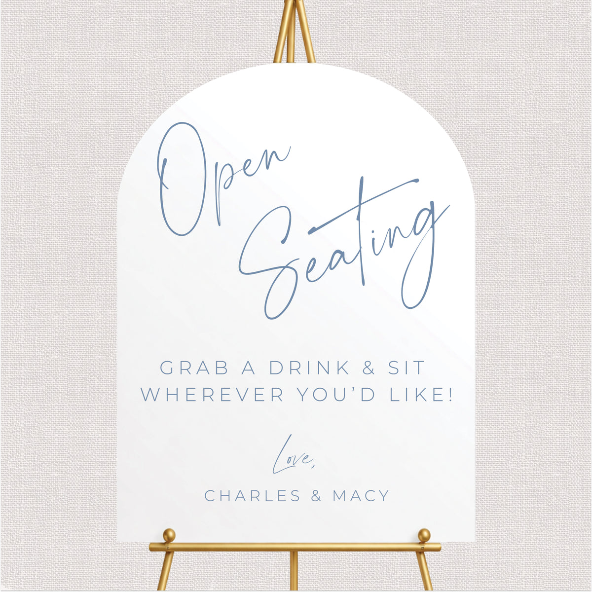 Elegant arched open seating wedding sign with dusty blue script lettering, personalized couple's names, and grab a drink and sit anywhere message.