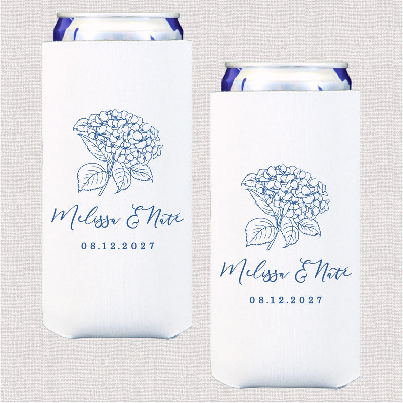 A pair of white slim fabric can coolers, each featuring a blue outline illustration of a hydrangea floral bouquet, designed to keep drinks cool for a wedding.